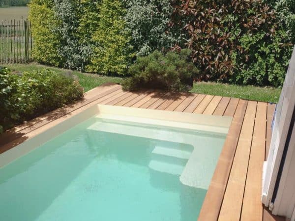 piscine coque MARGOT avec terrasse bois vue sur l'escalier. La marque COLETTE