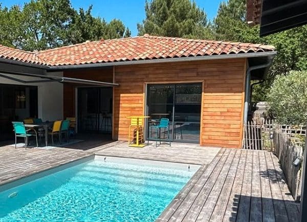 piscine coque JEANNE implantée dans jardin avec terrasse bois